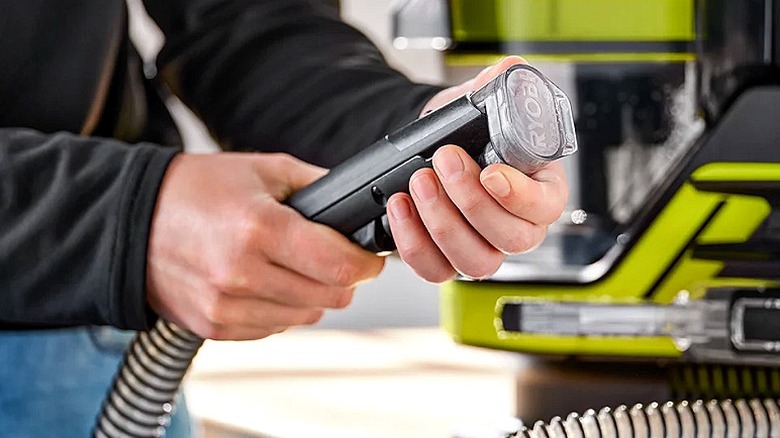 Ryobi spot ve halı temizleme makinesinin başlığını ayarlayan bir kişi