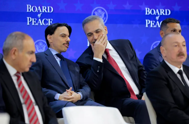 DAVOS, İSVİÇRE - 22 OCAK: ABD Başkanı Donald Trump, 22 Ocak 2026'da İsviçre'nin Davos kentinde düzenlenen Dünya Ekonomik Forumu'nda (WEF) “Barış Kurulu”nu sunarken Suudi Arabistan Dışişleri Bakanı Faysal bin Farhan (solda), Türkiye Dışişleri Bakanı Hakan Fidan ile konuşuyor. ABD destekli “Barış Kurulu”, İsrail ile Hamas arasındaki savaş sonrasında Gazze Şeridi'ndeki kırılgan ateşkesi yönetmeyi amaçlıyor. Kurulun son yapısı doğrulanmadı. (Fotoğraf: Chip Somodevilla/Getty Images)