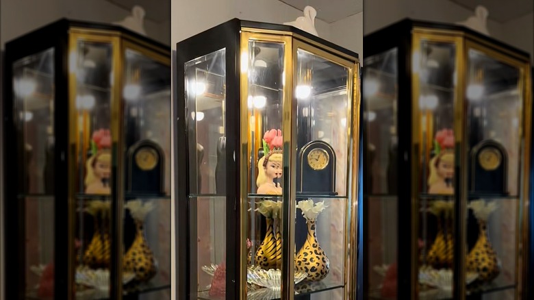 Raflarda vintage dekor parçaları bulunan pirinç antika dolabı