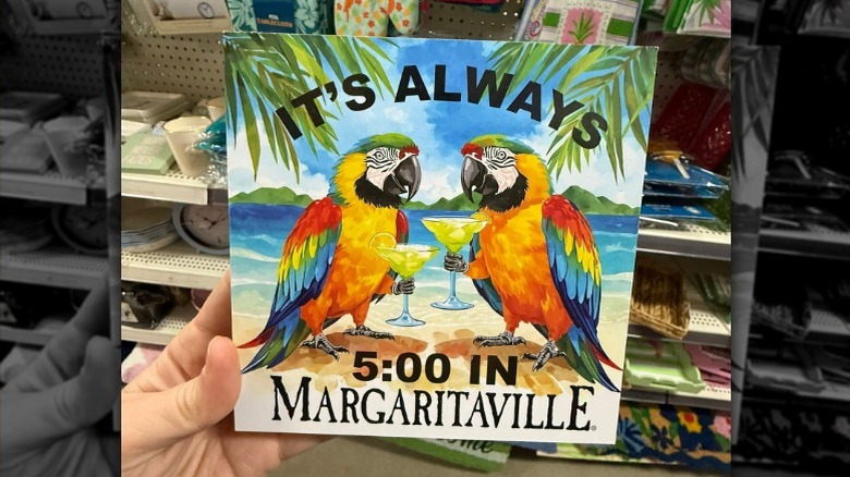 Margaritaville temalı dekor tabelasını tutan el.