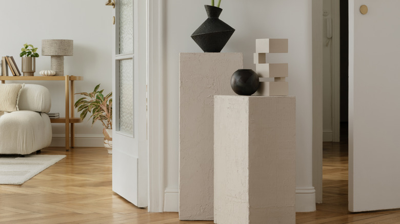 Üstünde sanatsal vazolar ve sanat objeleri bulunan modern sergileme kaideleri
