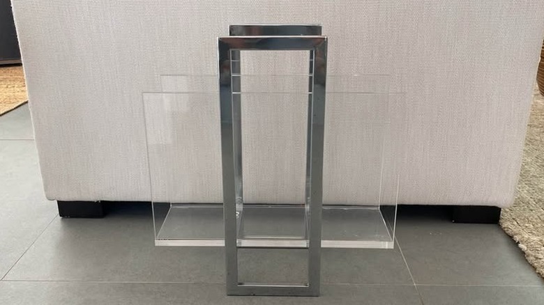 Dekoratif vazoların yanında taş yüzeyde kitap veya dergi bulunan Lucite dergi rafı