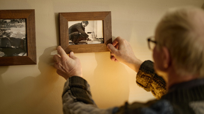 Duygusal bir siyah beyaz fotoğrafı duvara asan bir adam