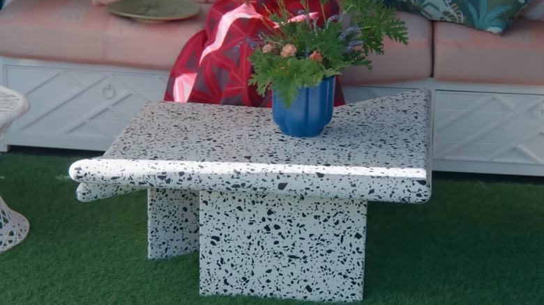 Isabel Ladd'in suni çimlerin üzerinde sergilenen beyaz ve siyah terrazzo sehpası.