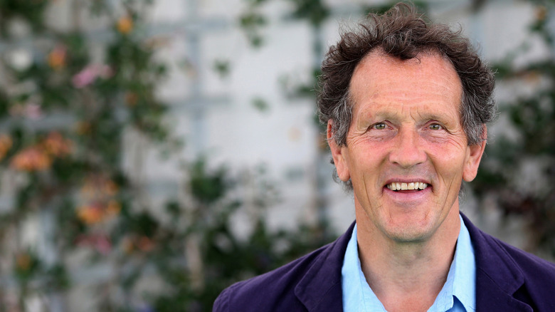 Monty Don arka planda bitkilerle mutlu bir şekilde gülümsüyor