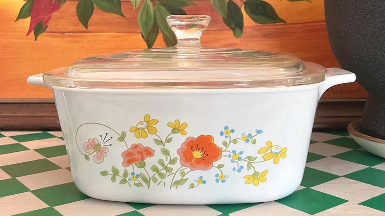 Yeşil kareli yüzey üzerinde kapaklı Vintage CorningWare Wildflower güveç tabağı