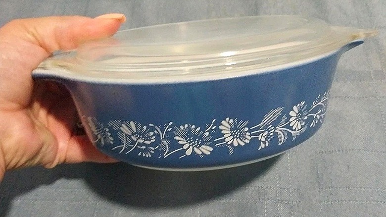 eBay'de satışa sunulan Colonial Mist Pyrex güveç kabını tutan elin yakın çekimi