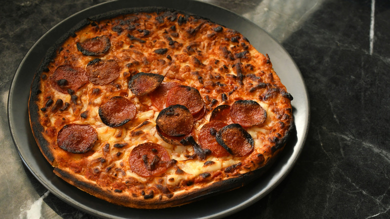 tabakta yanmış pizza