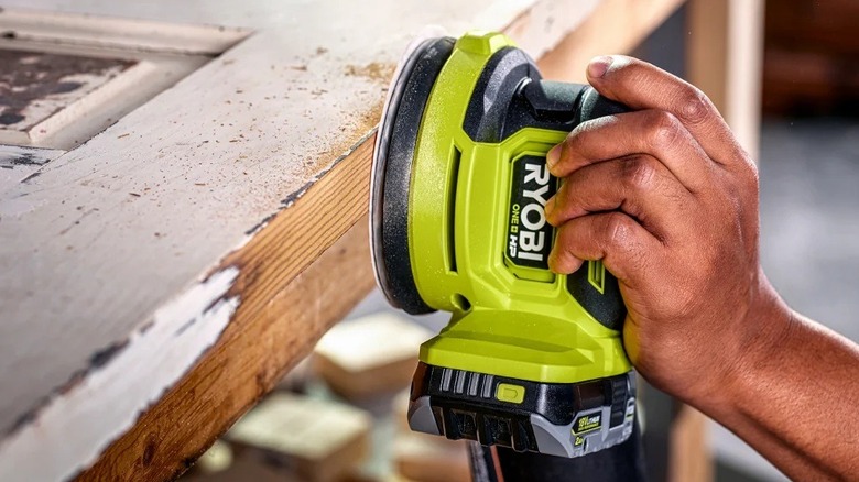 Ryobi yörünge zımparasını kullanan kişi