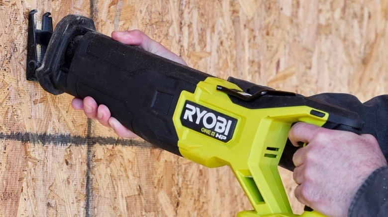 Ryobi panter testereyle kontrplağı kesen kişi