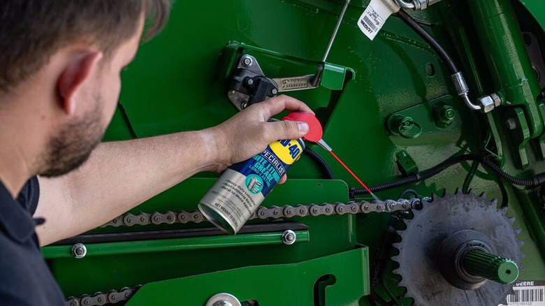 bir kişi zincire WD-40 Uzman Beyaz Lityum Gres sıkıyor