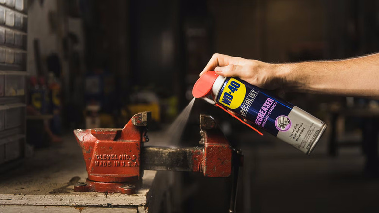 Birisi metal tezgah mengenesine WD-40 Uzman Yağ Gidericiyi sıkıyor