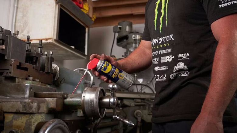 metal işleme torna tezgahına WD-40 Uzman Silikonu uygulayan kişi
