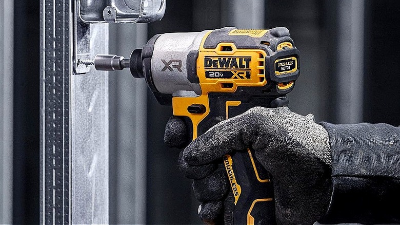 DeWalt elektrikli aletini kullanan eldivenli el