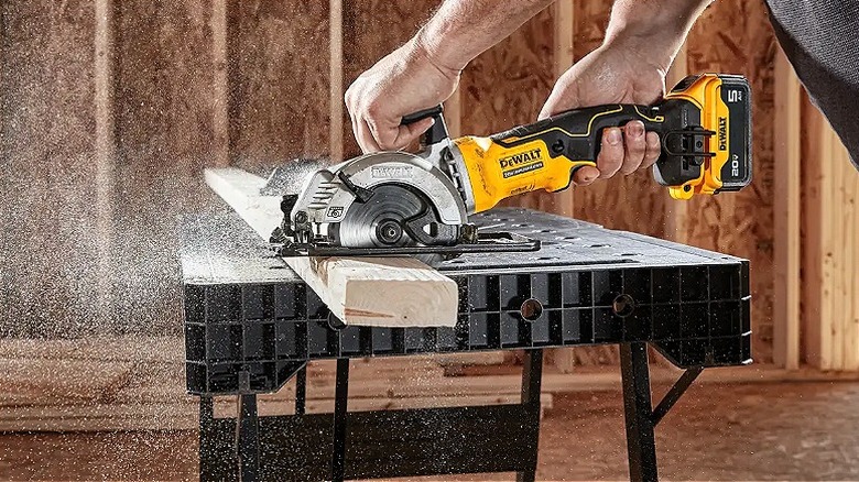Keresteyi kesmek için DeWalt testere kullanan bir kişi