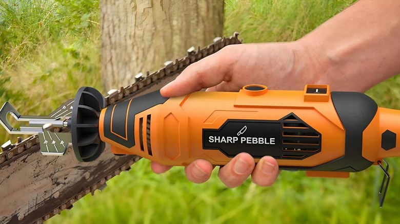 Sharp Pebble elektrikli testere bileyicisini tutan bir el
