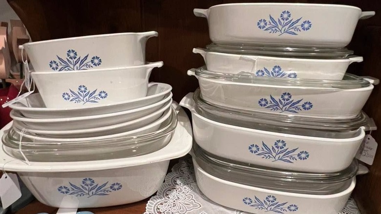 Bir bardak altlığı peçete üzerinde çeşitli boyutlarda Mavi Peygamber Çiçeği Corningware tabaklarından oluşan iç içe geçmiş yığın