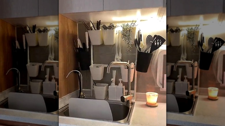 IKEA'dan SUNNERSTA mutfak düzenleyici rafı, mutfak eşyaları ve bitkilerle birlikte bir mutfakta sergileniyor.
