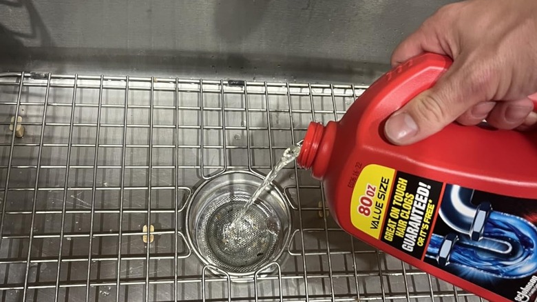 Drano Max Jel Kanal Tıkanıklığı Giderici ve Temizleyiciyi lavaboya döken bir kişi