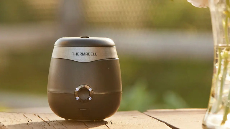 Thermacell E-ZoneGuard Patio Max Sivrisinek Kovucu ahşap bir masaya yerleştirildi