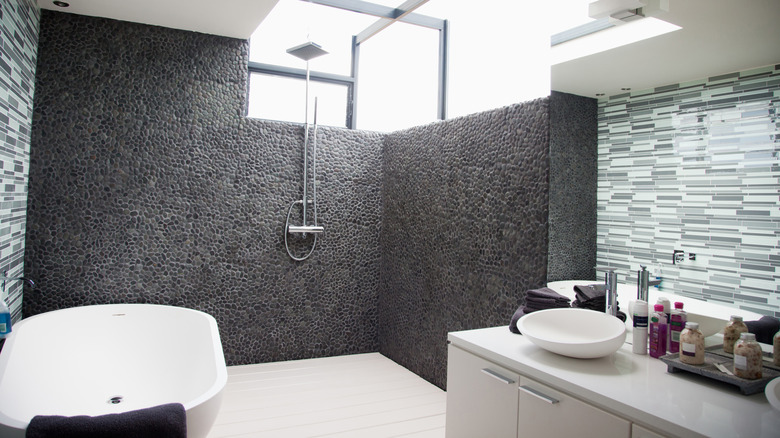 Tamamen açık duş ve banyo alanına sahip şık ve modern bir banyo.