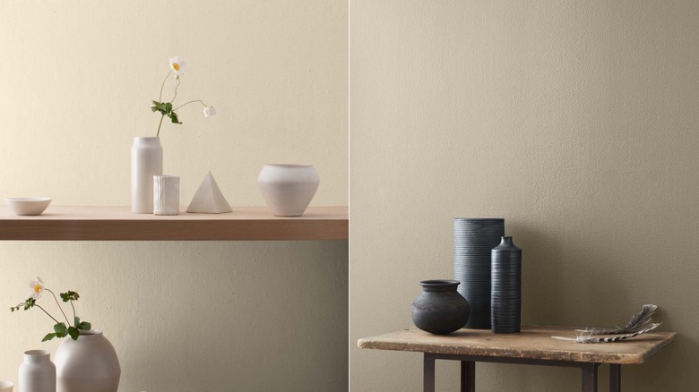 Benjamin Moore'un Manchester Tan / Wood masasında boyalı bir duvarın önündeki ahşap masanın üzerinde nötr renkli vazolar ve Pashmina ile boyanmış bir duvarın önünde siyah vazolar.