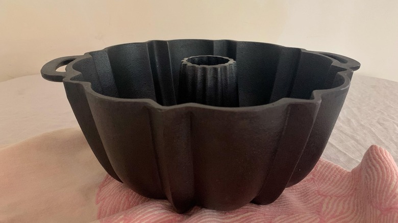 Bir kumaşın üzerine yerleştirilmiş eski bir dökme demir Bundt tavası