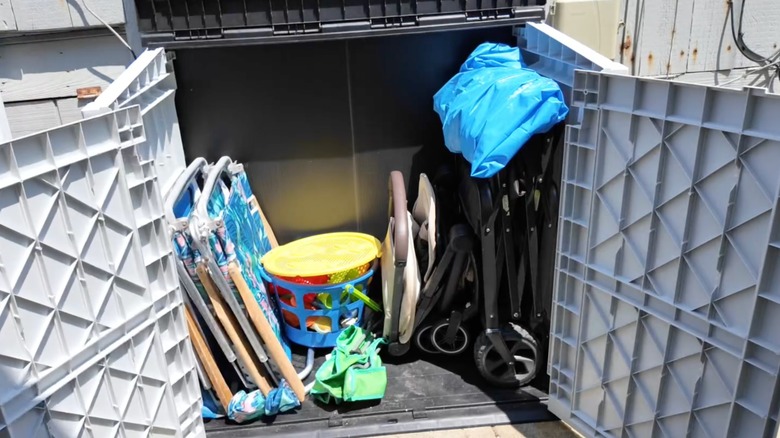 İçinde sandalyeler bulunan açık plastik bir bahçe barakası