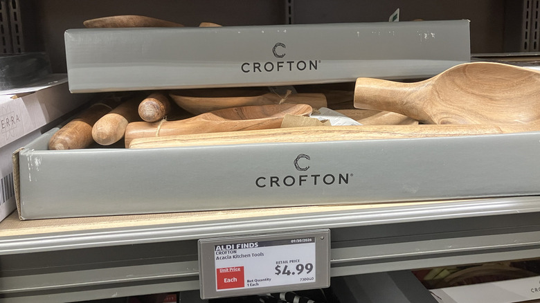 Aldi mağazası rafında akasya ağacından mutfak aletleriyle dolu Crofton markalı bir kutu.