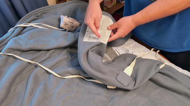 elektrikli battaniyenin etiketini işaret eden kişi