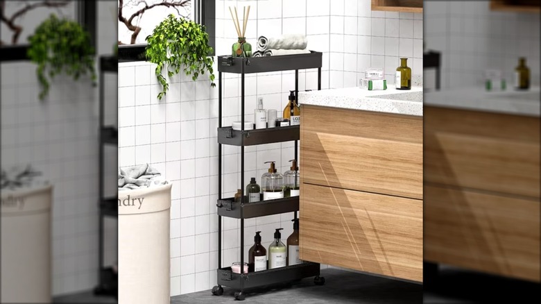 Makyaj masasının yanında banyo malzemelerinin bulunduğu ince plastik raf.