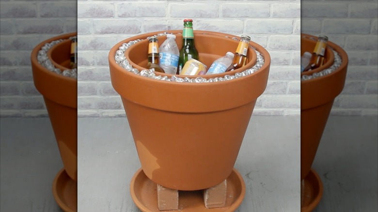 Su şişeleri, bira ve maden suyuyla doldurulmuş DIY pişmiş toprak kap içecek soğutucusu