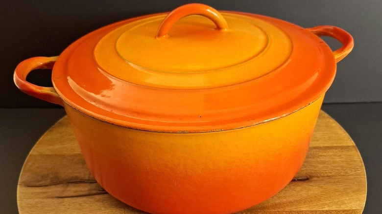 Kırmızı-turuncu renkte eski bir Le Creuset Dutch fırını