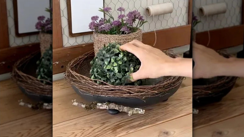 Çuval bezi, ince dallar ve eski bir kızartma tavası içeren katmanlı bir tepsi.